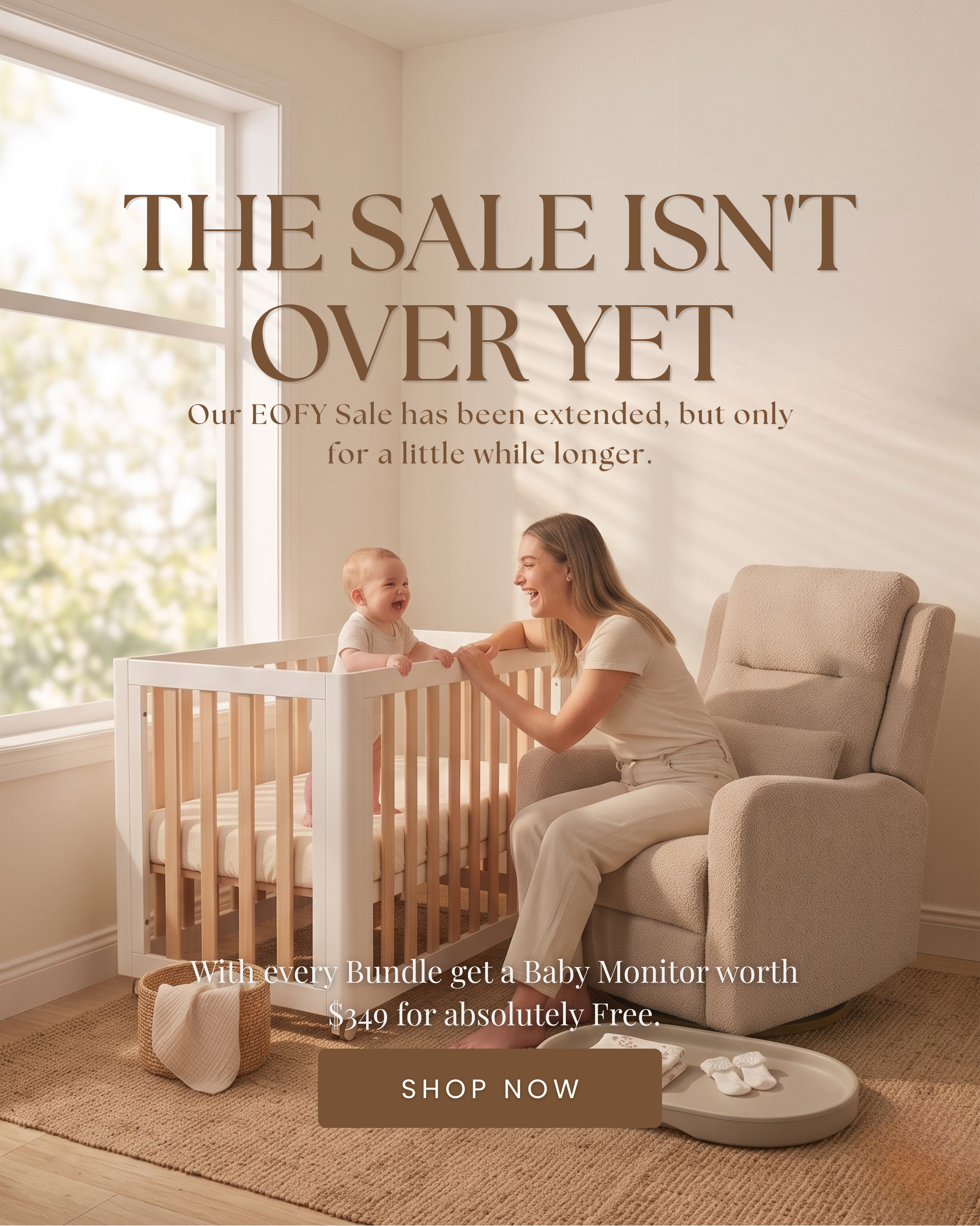 Mother smiling at a laughing baby standing in a Cocoon Piccolo cot beside a nursery recliner chair — EOFY Sale extended on Cocoon nursery furniture bundles, free baby monitor worth $349 with every bundle purchase.